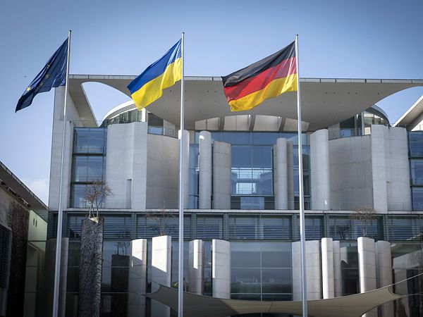 Vor dem Bundeskanzleramt wehen die europäische, ukrainische und deutsche Flagge
